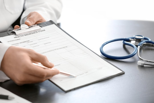 Doctor showing insurance form at table