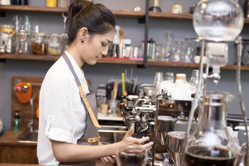Asian Barista woman making Coffee with coffee machine in the coffee shop. people with barista in cafe concept.