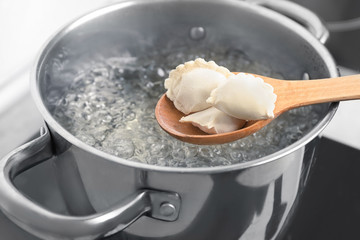 Fototapeta na wymiar Cooking dumplings in boiling water, closeup