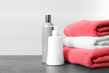Fototapeta na wymiar Clean towels and toiletries on table