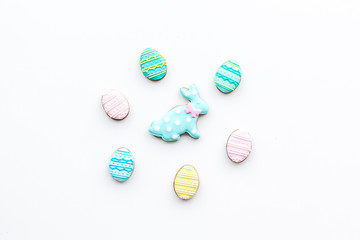 Sweets for celebrate Easter. Gingerbread in shape of easter bunny and easter eggs. White background top view copy space