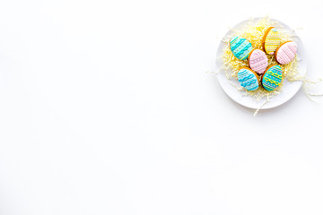 Sweets for celebrate Easter. Gingerbread in shape of easter eggs. White background top view copy space