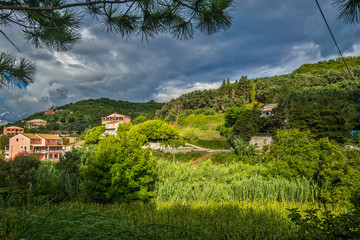 Traditional greek village in mountain at storm cloudy weather. Corfu, Greece.