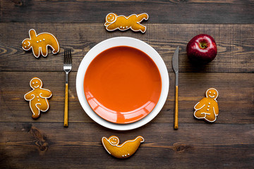 Yoga and healthy diet for lose weight. Plate, apple and cookies in shape of yoga asans on dark wooden background top view mock up