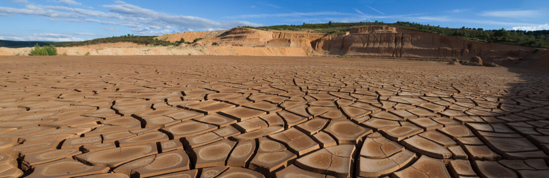 Balsa de deposito de Lodos con la tierra arcillosa agrietada al perder humedad. Desmonte en paisaje de gravera 