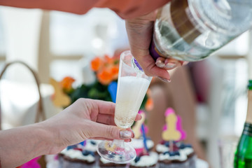 Group of girls celebrating - pouring champagne in glasses and drinking. Cheerful bride and bridesmaids party before wedding. Women having fun.  Colorful, funny and obscene background