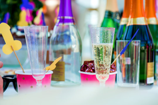 Mature content. Cheerful bride and bridesmaids party. Bottles of champagne and cupcakes with berries and penis decorations on toothpicks. Colorful, funny and obscene background