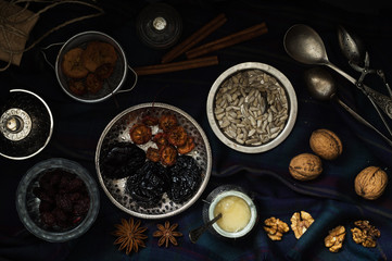 Various nuts and dried fruits in metal dishes on the table. Top view