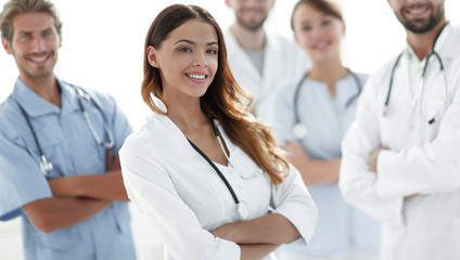 Fototapeta premium Attractive female doctor with medical stethoscope in front of medical group