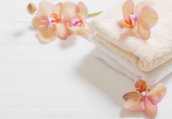 Fototapeta na wymiar orchid with towels on white wooden background