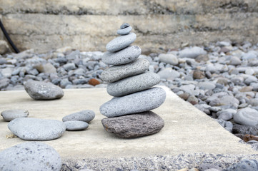 Fototapeta na wymiar Stone cairn tower, poise stones, rock zen sculpture, light grey pebbles