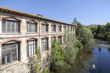 Fototapeta na wymiar Ancient factory building over river.Olot,Catalonia,Spain.
