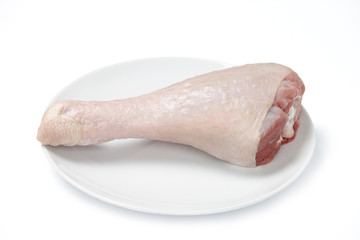 Turkey drumstick with skin in big plate isolated on white background