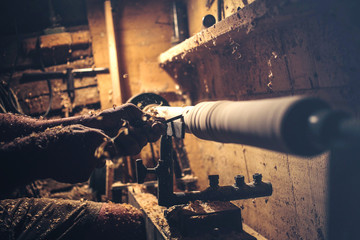 Artisan carves a piece of wood using a manual lathe 