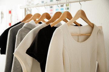Women dresses new collection of stylish clothes wear hanging on hangers clothing rack rails, fabric samples at background, fashion design studio store concept, dressmaking tailoring sewing workshop - Powered by Adobe