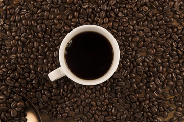 Cup of coffee and coffee beans on old wooden background. Directly above.