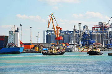 Naklejka premium Tugboat assisting container cargo ship
