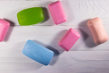 Set of colorful soap on white wooden background