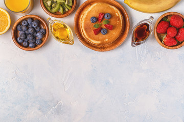 Pancakes with fruit, honey, maple syrup.