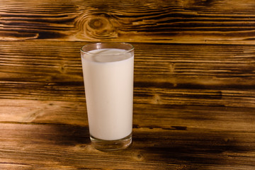 Full glass of milk on a wooden table