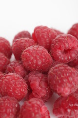 lot of red raspberry on white background