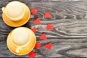On a wooden background are the hearts with a cup of coffee. Valentine's day concept.