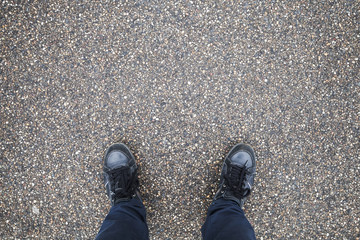 Male feet stand on street asphalt