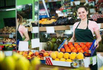 Grocery worker offering persimmons