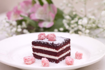 piece of cake on Valentine's day, sweet and fragrant with pink candies and a bouquet of pink flowers
