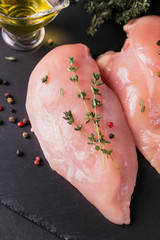 Raw chicken fillets with spices and herbs.