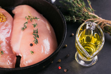 Raw chicken fillets with spices and herbs.