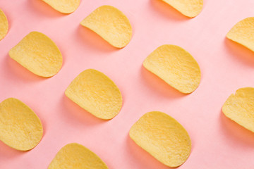 Potato chips on pastel pink background in minimalism style.