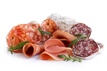 Mixed air cured sliced meats isolated on white. Rocket garnish.