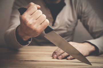 Caucasian criminal showing knife.