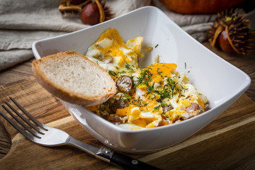 Scrambled eggs with sausage and bread.