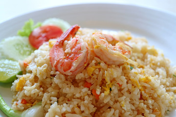 Closed up Thai style shrimp fried rice served on white plate with selective focus and blurred background 