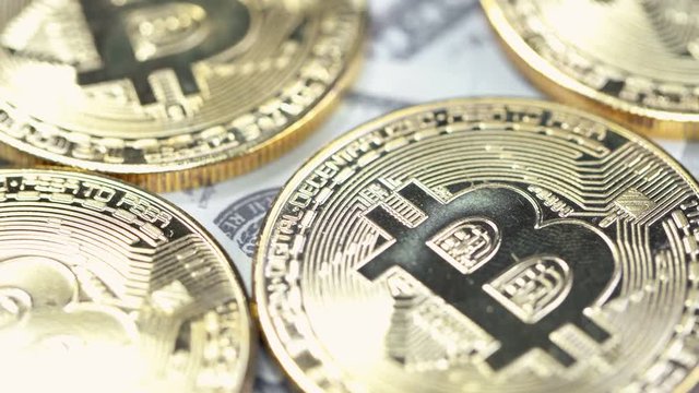 Bitcoins on dollar banknotes background, closeup