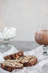 Pieces of chocolate cake from cookies and cocoa with marshmallow on bakery paper High key Still life food style Hugge scandinavian nordic