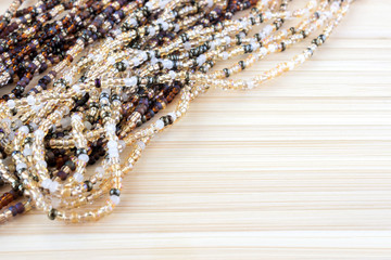 Multicolor beads. Nice, brown, dark yellow and beige beads on old wooden colored background. Place for text, copyspace. An old style vintage background.