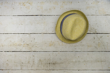 straw hat on white wood wall. Vintage style Use it as a background or holiday concept.