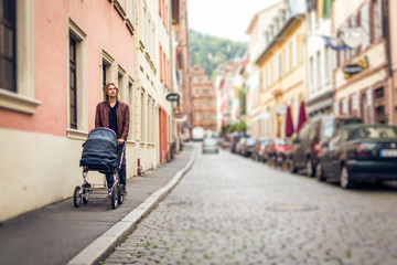 Fototapeta na wymiar Young Father With Baby Stroller In The City