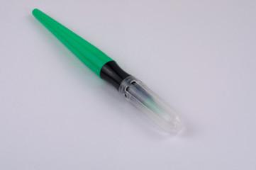 Single new smooth green marker brush with plastic tip on white background