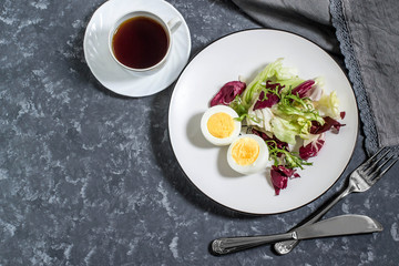 Light breakfast. Boiled eggs, salad mix and cup of coffee