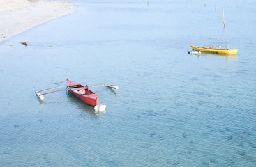 red and yellow canoe floating on the sea.