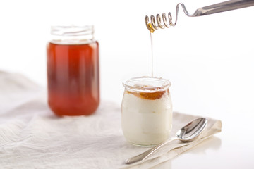 Yogurt in glass jar with spoon and honey