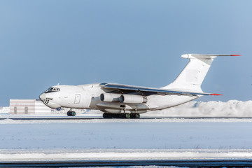 White large soviet cargo aircraft taking off at airport