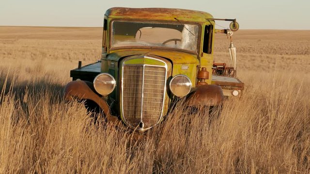 Old abandonded farm truck in windy field close 4K