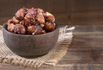Sugared peanuts on the wooden background - Arachis hypogaea