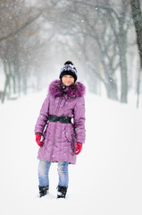 Fototapeta na wymiar happy girl teenager in the purple coat in winter