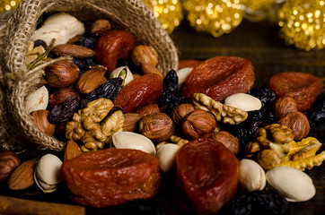 nuts, dried fruits, pistachios and other scattered from the bag on the table